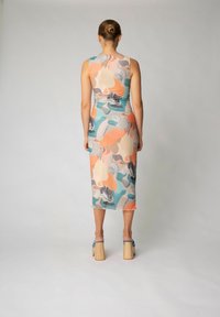 Bodycon-klänning med ett färgglatt abstrakt mönster i persika, turkos och grått, tillverkad av ett lätt och elastiskt tyg, knälång enkel design.