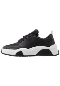 Black and white chunky sneaker with lace-up front, mesh and leather upper, branded "Versace Jeans Couture" on side and sole.