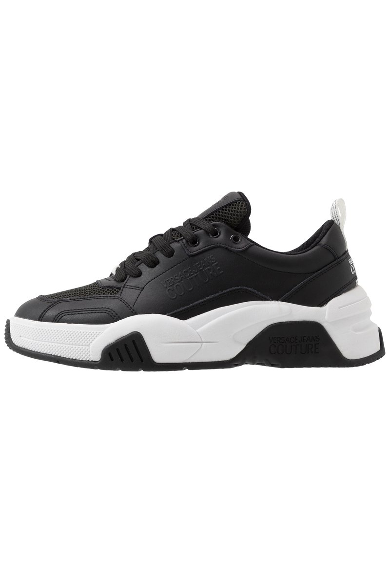 Black and white chunky sneaker with lace-up front, mesh and leather upper, branded "Versace Jeans Couture" on side and sole.