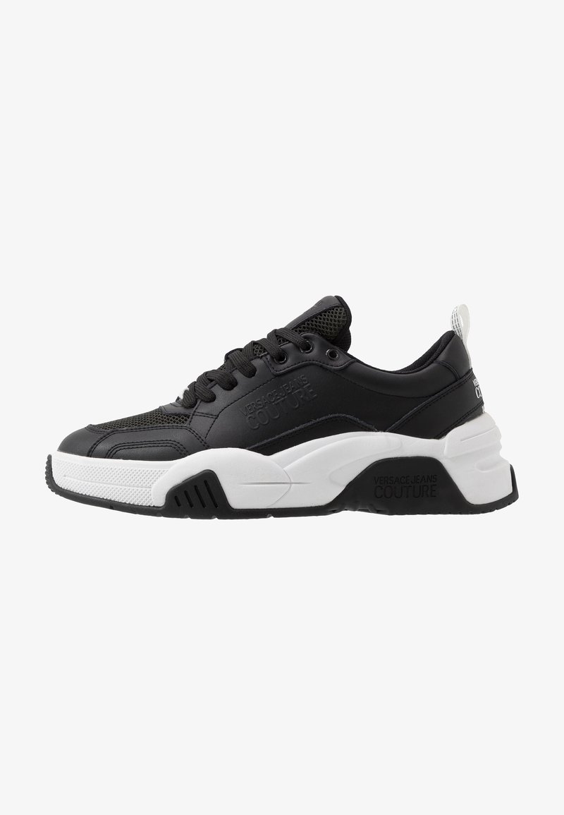 Black and white chunky sneaker with lace-up front, mesh and leather upper, branded "Versace Jeans Couture" on side and sole.