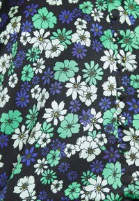 Czarna tkanina z kwiecistym wzorem w białe, zielone i fioletowe kwiaty; zawiera czarne guziki po bokach.