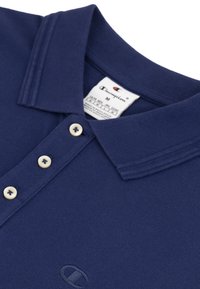 Granatowa koszulka polo wykonana z teksturowanej tkaniny, z klasycznym kołnierzykiem, trzema guzikami w kremowym kolorze oraz haftowanym logo.