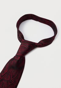 Krawat jedwabny w ciemnoczerwonym kolorze z fakturowanym, wirującym wzorem. Posiada klasyczny kształt i wąską szerokość, zaprojektowany do formalnego stroju.