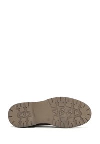 Suela de goma marrón con patrones de agarre texturizados y un talón reforzado. Diseño plano sin costuras visibles ni acentos.
