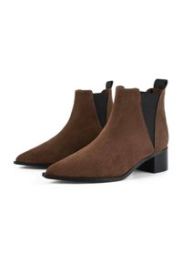 Stivali alla caviglia in suede marrone con punta affusolata, pannelli laterali elasticizzati e tacco basso a blocco. Superficie testurizzata con una suola liscia e scura.