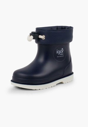Bota de goma impermeable en azul marino con suela blanca, puño elástico y acento de cuerda ajustable. Presenta un logo en el costado.