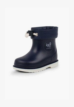 Botte en caoutchouc imperméable marine avec une semelle blanche, un manchon élastique et un accent de corde ajustable. Présente un logo sur le côté.
