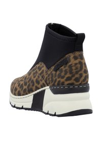 Bottines à imprimé léopard avec une tige en tissu noir et une semelle plateforme blanche. Présentent un talon texturé et un panneau latéral élastique pour un enfilage facile.