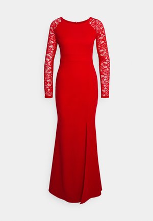 Punane kleit pikkade pitsi varrukatega, kehasse liibuv ja sirge seelikuosa, millel on reie kõrge lõhik. Sile kangas lillepitsist detailidega.