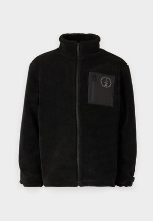 Schwarze Fleecejacke mit hohem Kragen, Frontreißverschluss und einer linke Brusttasche mit schwarzem Stoffklappen und Logodetail. Weiche Textur.