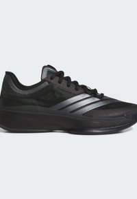 Baskets de sport noires avec une tige en mesh, finition texturée, semelle courbée et rayures argentées sur les côtés. Elles disposent de lacets noirs et d'un col rembourré.