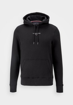 Schwarzer Hoodie mit Fronttasche, verstellbarer Kordelzugkapuze und kleinem weißen "Tommy Hilfiger EST. 1985" Schriftzug auf der Brust.