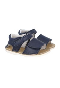 Sandalias de cuero azul marino con la parte trasera cerrada, los lados abiertos y dos tiras ajustables de velcro. Suelas blancas con detalles de costura.