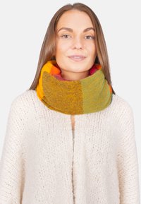 Farbenfroher Strick-Infinity-Schal mit Schattierungen von Gelb, Orange, Grün und Rot aus einem weichen, strukturierten Stoff, der um den Hals getragen wird.