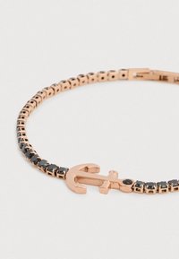 Rozéarany karkötő horgony medállal, fekete drágakő díszítéssel egy rugalmas, kis négyzet alakú láncszemekből álló láncon.