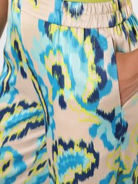 Losse, lichtgewicht pantalons van een beige stof met een abstract blauw en groen patroon. Elastische tailleband met zakken.