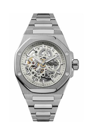 Automatische Armbanduhr mit skelettiertem Zifferblatt aus silbernem Edelstahl, sichtbaren Zahnrädern, leuchtenden Zeigern und Metallglied-Armband.