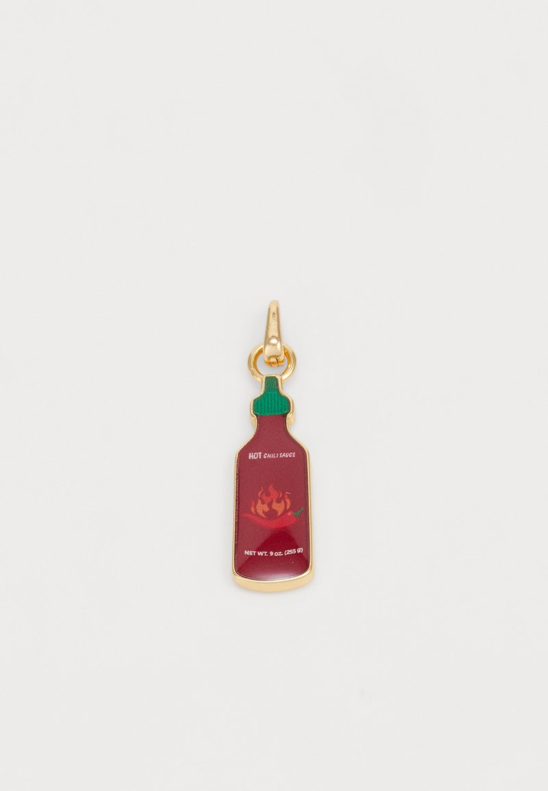 Porte-clés en forme de bouteille de sauce chili rouge avec un couvercle vert, des accents dorés et des détails graphiques y compris des flammes et du texte, ressemblant à un contenant de condiments.