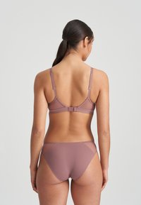 Bra and brief set in soft mauve, featuring adjustable straps, a mesh panel at the back, and a smooth texture. Minimalist design highlights comfort.