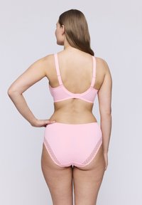 Ljust rosa underkläder i set som består av en bh med justerbara axelremmar och en trosa med spetsdetaljer på sidorna. Slät, mjuk textur.