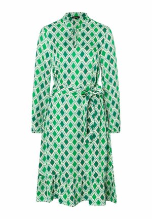 Robe midi à manches longues aux motifs géométriques verts et blancs, avec col, détail noué au cou, ceinture à la taille et ourlet à volants.