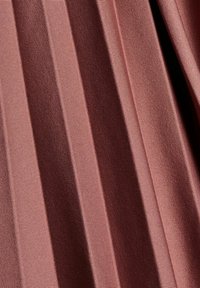Gros plan d'un tissu satin rayé rose foncé et marron avec une texture lisse et brillante et des plis subtils.