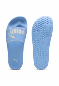 Himmelblå rutsesandaler med en struktureret overdel, der har et hvidt Puma-logo. Sålen har et honningkombinationsmønster for traction.