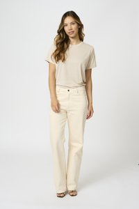 Beige tričko s krátkým rukávem v kombinaci s kalhotami s širokými nohavicemi v jemné krémové barvě. Měkká textilie, klasický střih a jednoduchý design.