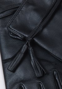 Black leather gloves featuring a smooth texture, narrow fit, and decorative tassel accents near the wrist. Stitched detailing enhances design.