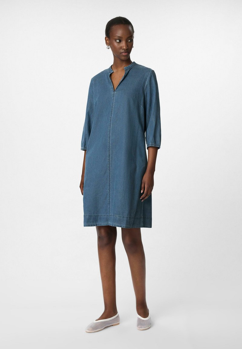 Dunkelblaues Denim-Kleid mit einem kragenlosen Ausschnitt, Dreiviertelärmeln und seitlichen Taschen. Glatte Textur, knielanger Schnitt.