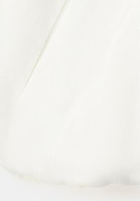 Biely textilný materiál zblízka zobrazujúci mäkké záhyby a jemné textúrované tkanie.