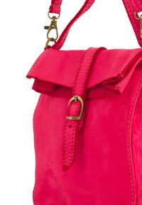 Jasnoróżowa skórzana torebka typu crossbody z klapką na górze, detalami w formie klamry i plecionym paskiem. Posiada gładką fakturę i kontrastowe przeszycia.