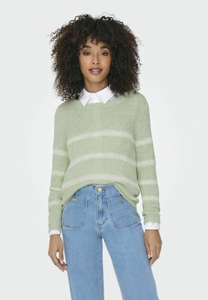 Lichtgroene gestreepte trui met een losse pasvorm, geribbeld textuur en een V-hals. Gecombineerd met hoge taille blauwe denim jeans en een witte overhemd met kraag.