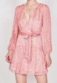 Rosa blommig omslagsklänning med långa ärmar, knytmidja och volangkant. Det lätta tyget har ett texturerat mönster av löv.