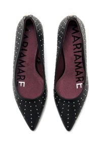 Chaussures plates noires à bouts pointus, ornées de clous en argent. L'intérieur présente une semelle intérieure bordeaux avec une marque en noir.