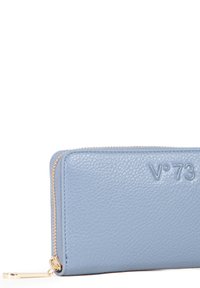 Portafoglio in pelle azzurro chiaro con superficie strutturata, dotato di una zip dorata e logo in rilievo. Bordi arrotondati e profilo sottile.