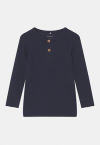 Mørkeblå langermet topp i ribbestrikket stoff med rund hals, med to treknapper foran og rett nederkant.