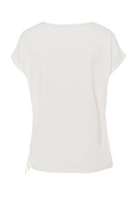 Haut blanc à manches courtes avec un col rond et un détail de cordon sur le côté. Tissu doux, coupe décontractée et texture lisse.