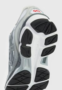 Grå och vit atletisk skosula med svarta texturerade mönster och texten "Guide Line 3D" på mellansulan.