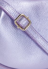 Borsa a tracolla in pelle viola con finitura texturizzata, caratterizzata da una fibbia e una tracolla dorate, che evidenziano la sua superficie liscia e lucida.