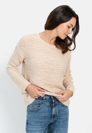 Light beige knitted sweater with a textured pattern, round neckline, and long sleeves, paired with blue jeans. Subtle horizontal stripes.