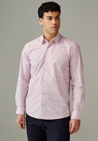 Camicia con bottoni rosa chiaro con motivo floreale, maniche lunghe e collo a punta; realizzata in tessuto liscio con una lucentezza sottile.