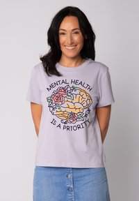 Licht lavendelkleurig t-shirt met korte mouwen, voorzien van een geïllustreerde hersenen omringd door rozen, met de tekst "MENTALE GEZONDHEID IS EEN PRIORITEIT."