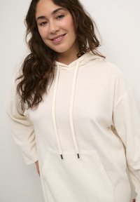 Helle Kapuzenpullover aus weichem Material, mit Kordelzug und einer Fronttasche. Bietet eine lockere Passform und lange Ärmel.