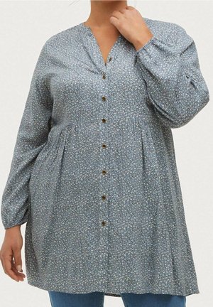 Blå, langærmet skjorte med knapper og V-hals, dekoreret med blomsterprint og en smal talje. Stoffet virker blødt med en let glans.