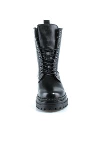 Botte de combat en cuir noir avec une semelle épaisse et des lacets, vue de face sur fond blanc.