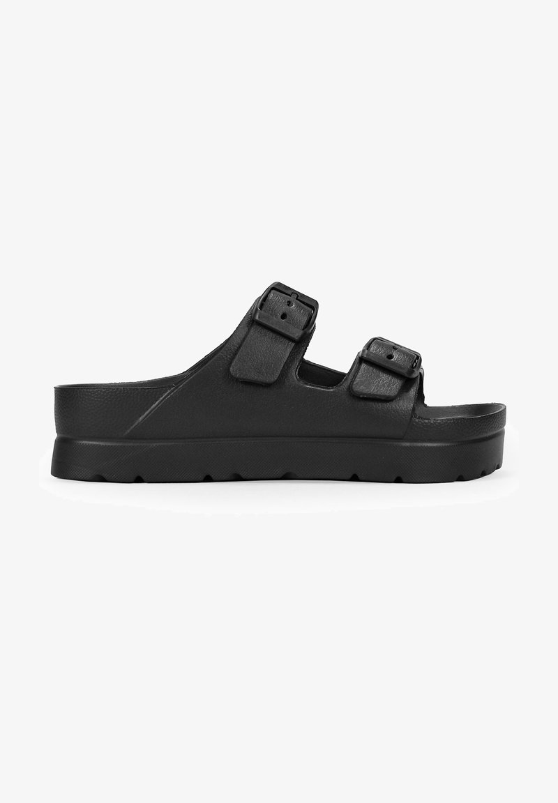 Black slip-on sandal with two adjustable straps, made of textured synthetic material, featuring a thick platform sole with a tread pattern.