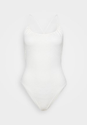 Hvit heldraktbikini med en strukturert bølgeknipling, justerbare tynne stropper og dyp halsringning.