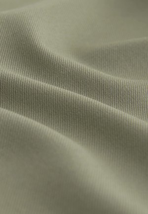 Groen stof met een zachte, textuurrijke oppervlakte; heeft fijne ribbels en gladde plooien, die diepte en dimensie aan het materiaal geven.
