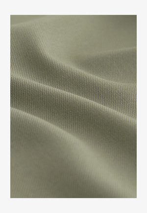 Tessuto verde con superficie morbida e texture; presenta sottili coste e pieghe lisce, creando profondità e dimensione nel materiale.